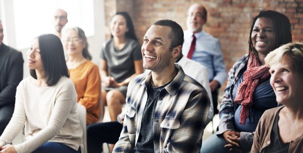 A group of people sitting, listening to a presentation