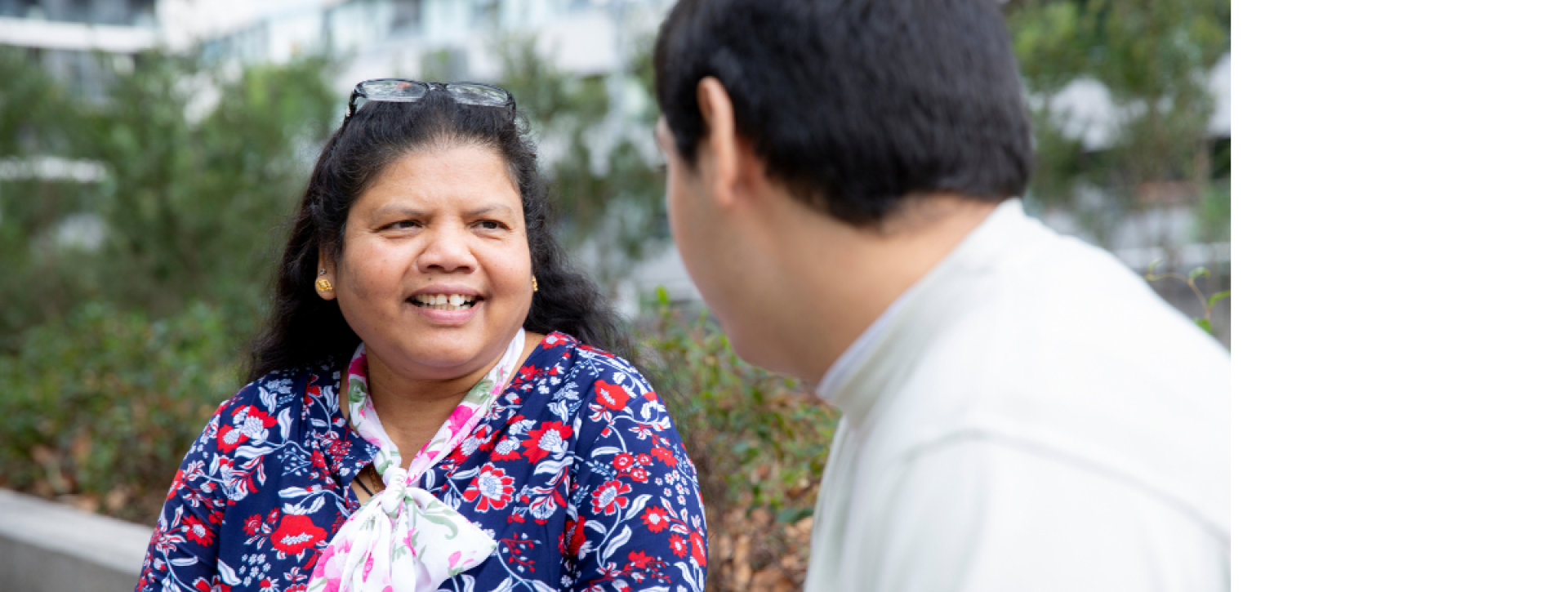 Woman talking to a man, his head is obscured
