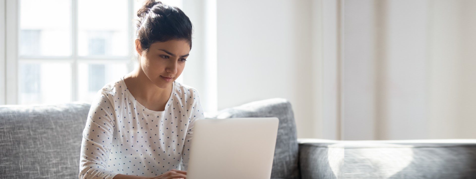 Woman using laptop on a couch