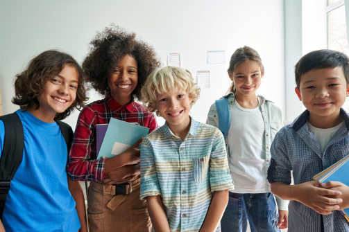 a diverse group of young school children together in a classroom