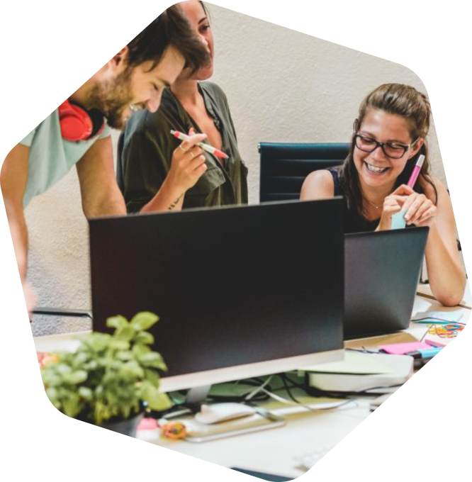 Three people at a desk looking at a computer monitor.