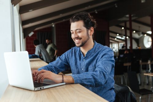 Man smiling on a laptop
