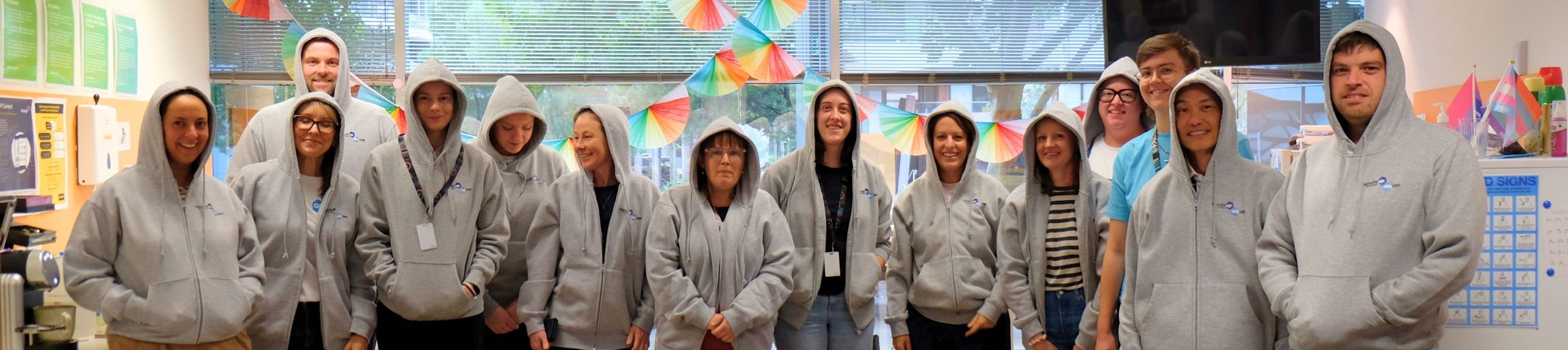 Group of people wearing hoodies up in an office