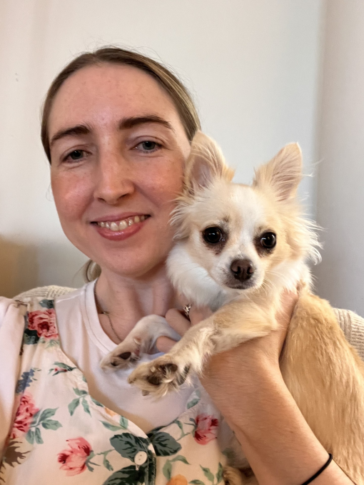 A woman holding up her Chihuahua